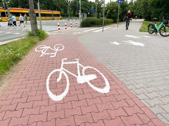 Photo of Street with road, pedestrian zone and red paved bicycle lane