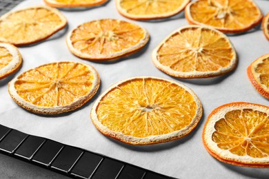 Photo of Dry orange slices on parchment paper, closeup