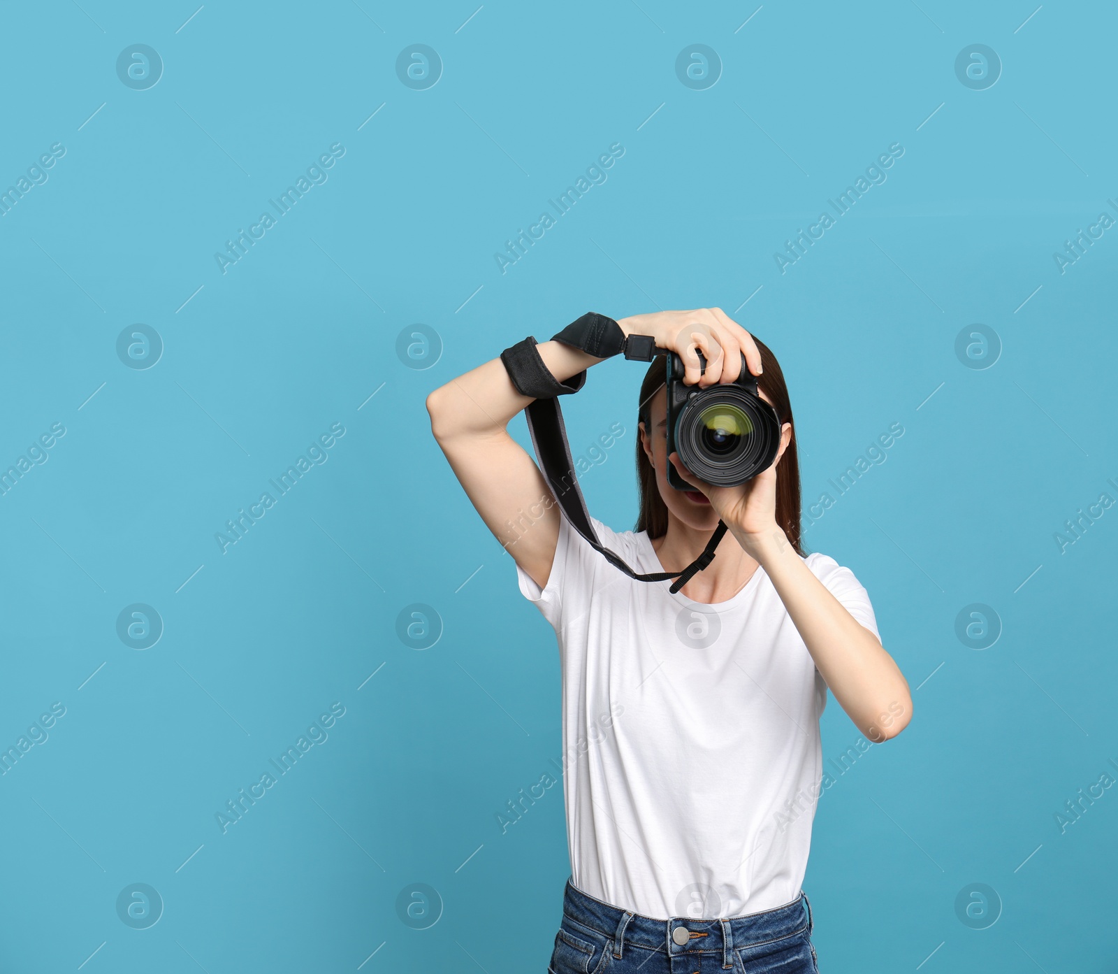 Photo of Professional photographer taking picture on light blue background