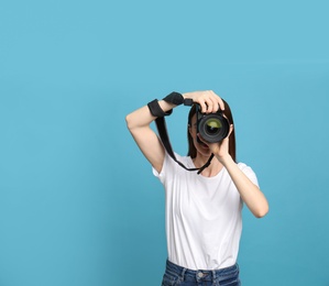 Photo of Professional photographer taking picture on light blue background