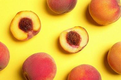 Delicious juicy peaches on yellow background, flat lay