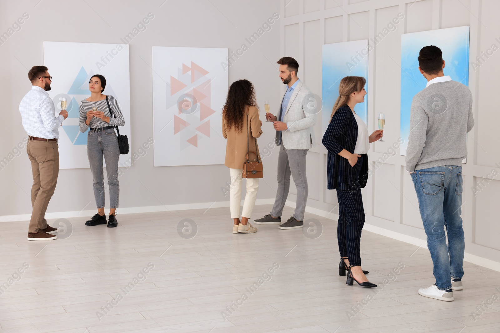 Photo of People viewing exposition in modern art gallery