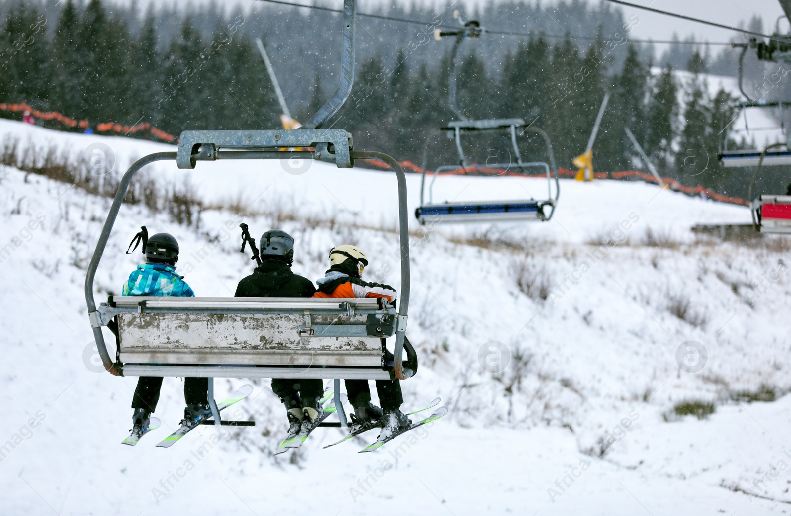 Photo of Chairlift with people at ski resort. Winter vacation