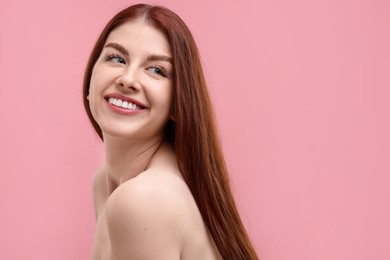 Portrait of smiling woman with freckles on pink background. Space for text