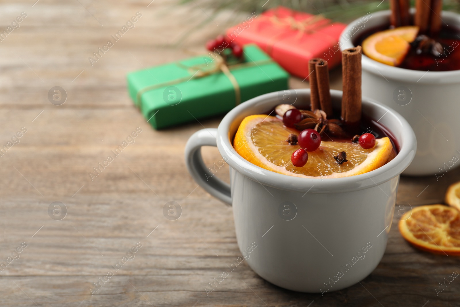 Photo of Cup with tasty mulled wine on wooden table