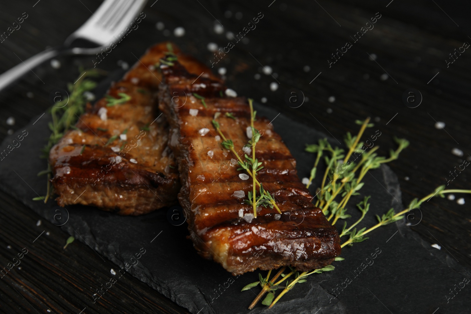 Photo of Board with grilled meat on wooden table
