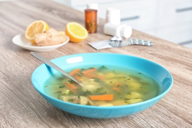 Photo of Bowl with delicious hot broth on table. Cold treatment