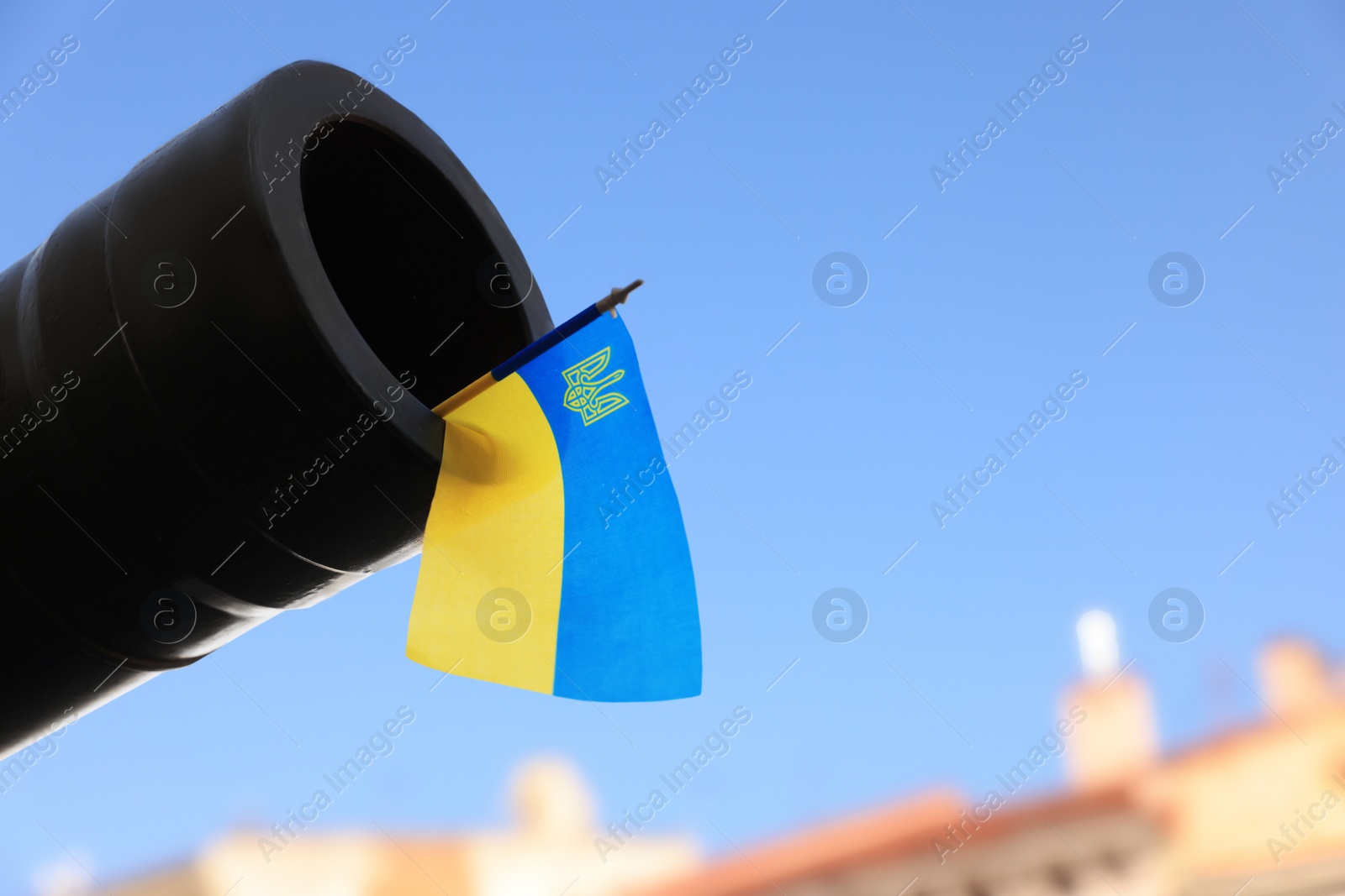 Photo of Ukrainian flag in muzzle of tank outdoors