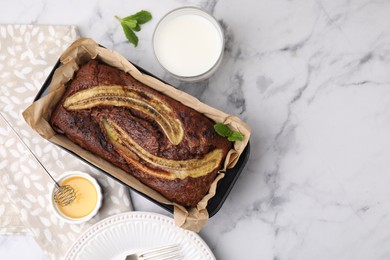 Photo of Delicious banana bread served on white marble table, flat lay. Space for text