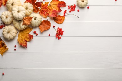 Flat lay composition with dry autumn leaves on white wooden table, space for text
