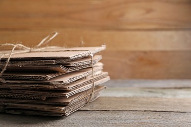 Photo of Stack of waste paper on wooden table, closeup. Space for text