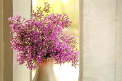 Photo of Beautiful lilac flowers in vase near window indoors, closeup