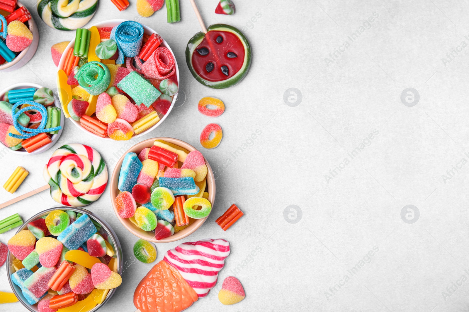 Photo of Many tasty colorful jelly candies on white table, flat lay. Space for text