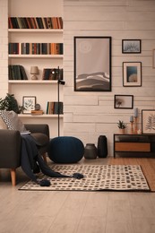 Photo of Cozy home library interior with comfortable sofa and collection of different books on shelves