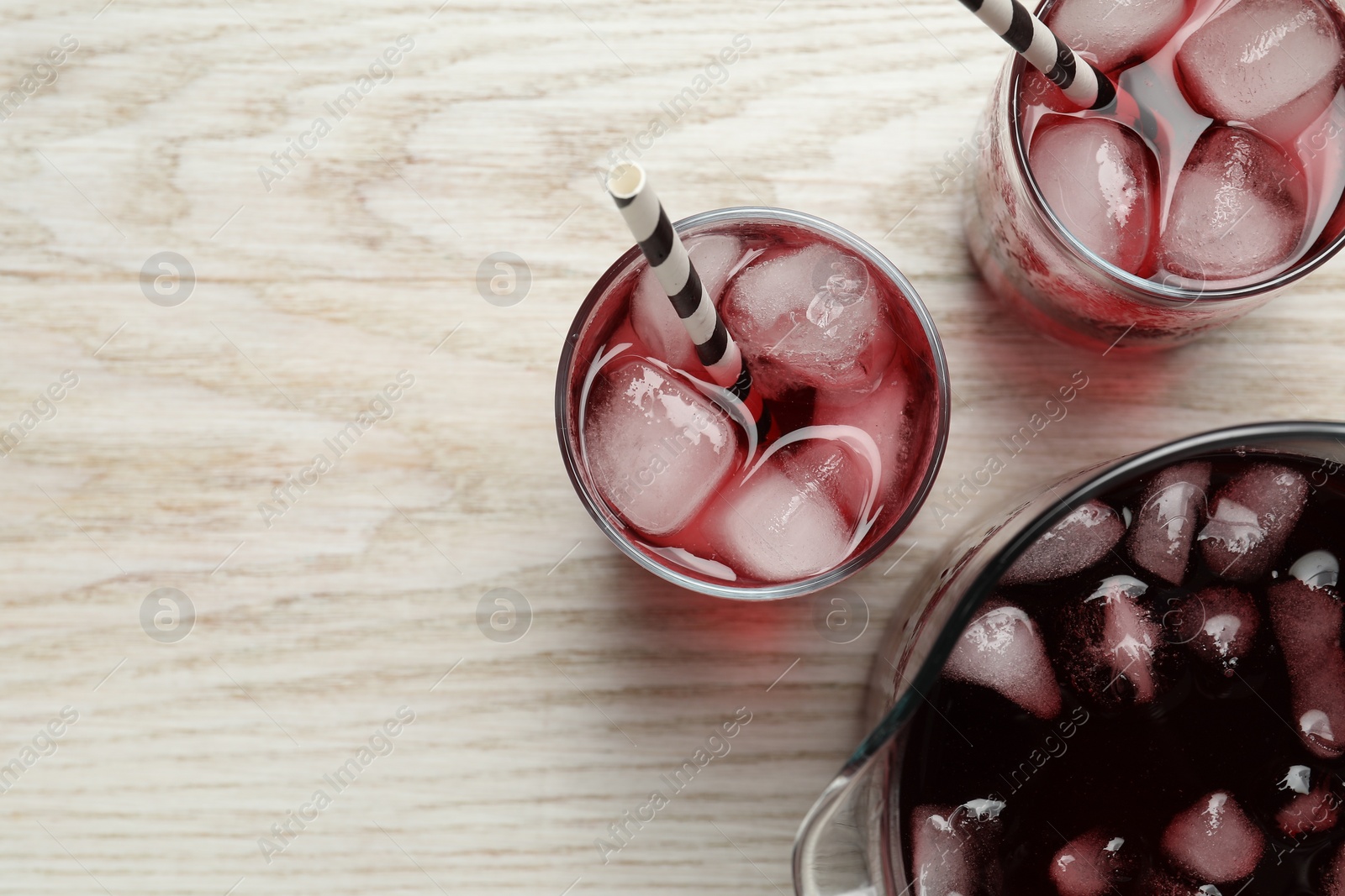 Photo of Delicious iced hibiscus tea on white wooden table, flat lay. Space for text