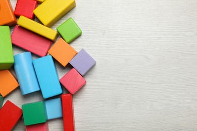 Photo of Colorful building blocks on wooden floor, flat lay. Space for text