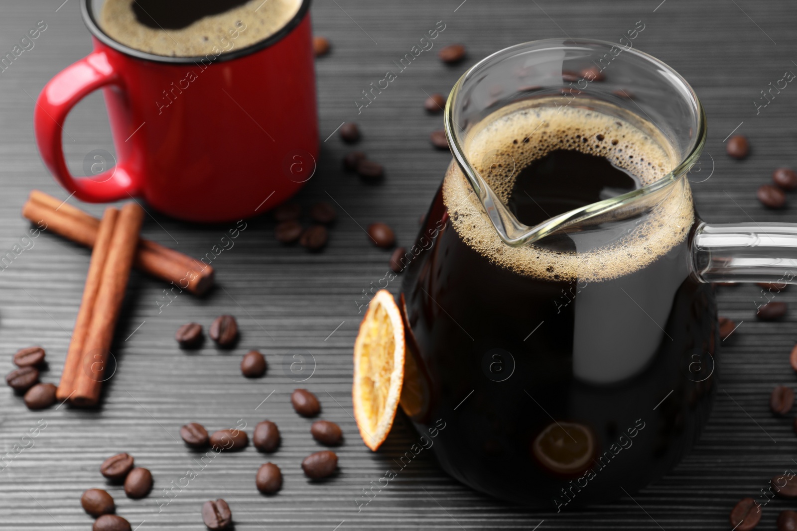 Photo of Turkish coffee in glass cezve and cup on grey wooden table. Space for text