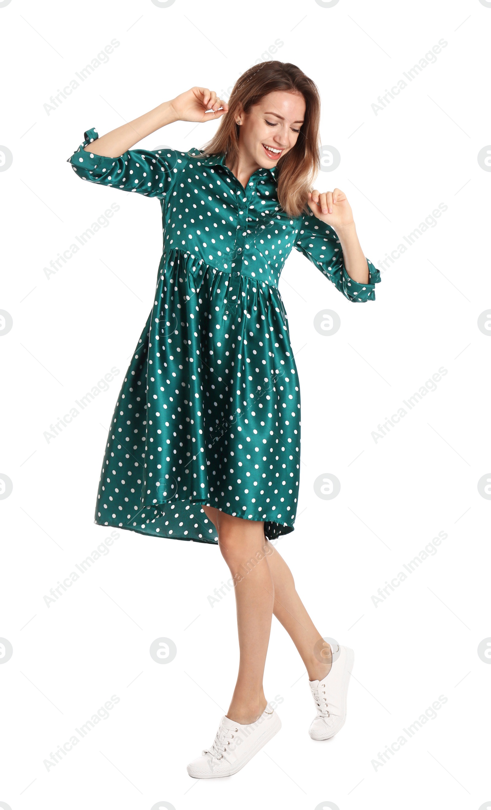 Photo of Beautiful young woman in green dress dancing on white background