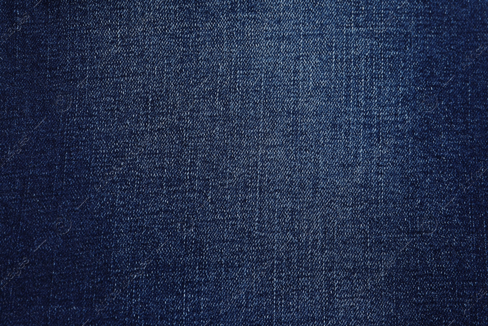 Photo of Texture of dark blue jeans as background, closeup