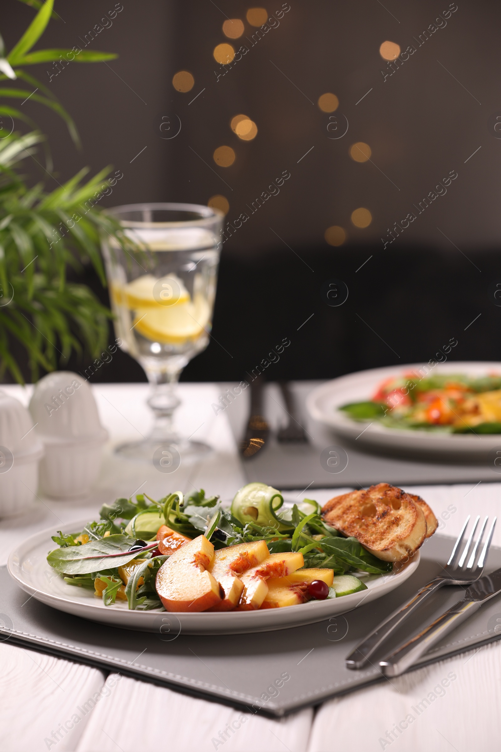 Photo of Delicious salad with peach slices served wooden table