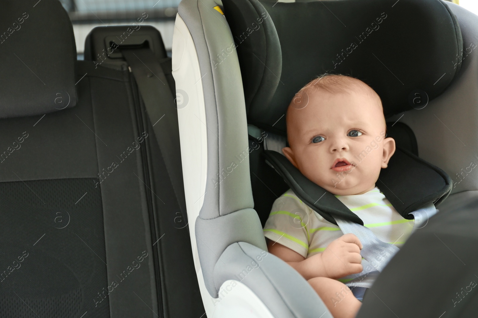 Photo of Little baby in child safety seat inside of car