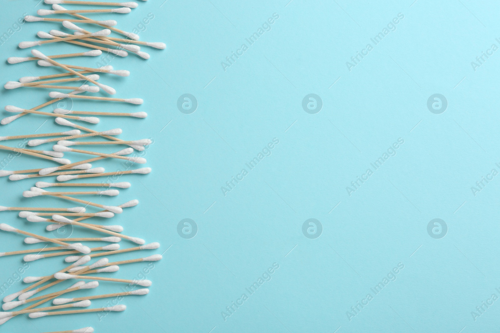 Photo of Flat lay composition with cotton swabs and space for text on color background