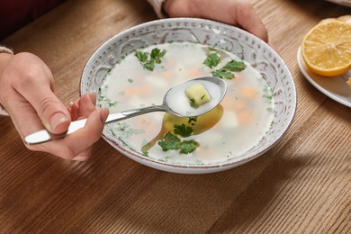 Photo of Sick woman eating fresh homemade soup to cure flu at table, closeup