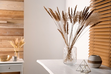 Dry plants on white table indoors. Interior design