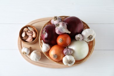 Photo of Fresh raw garlic and onions on white table, top view