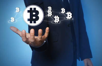 Image of Fintech concept. Businessman demonstrating scheme with bitcoin symbols