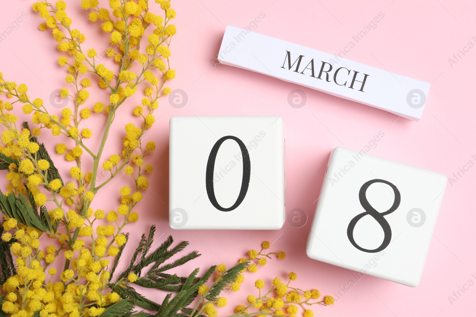 Photo of International Women's day - 8th of March. Wooden block calendar and beautiful flowers on pink background, flat lay