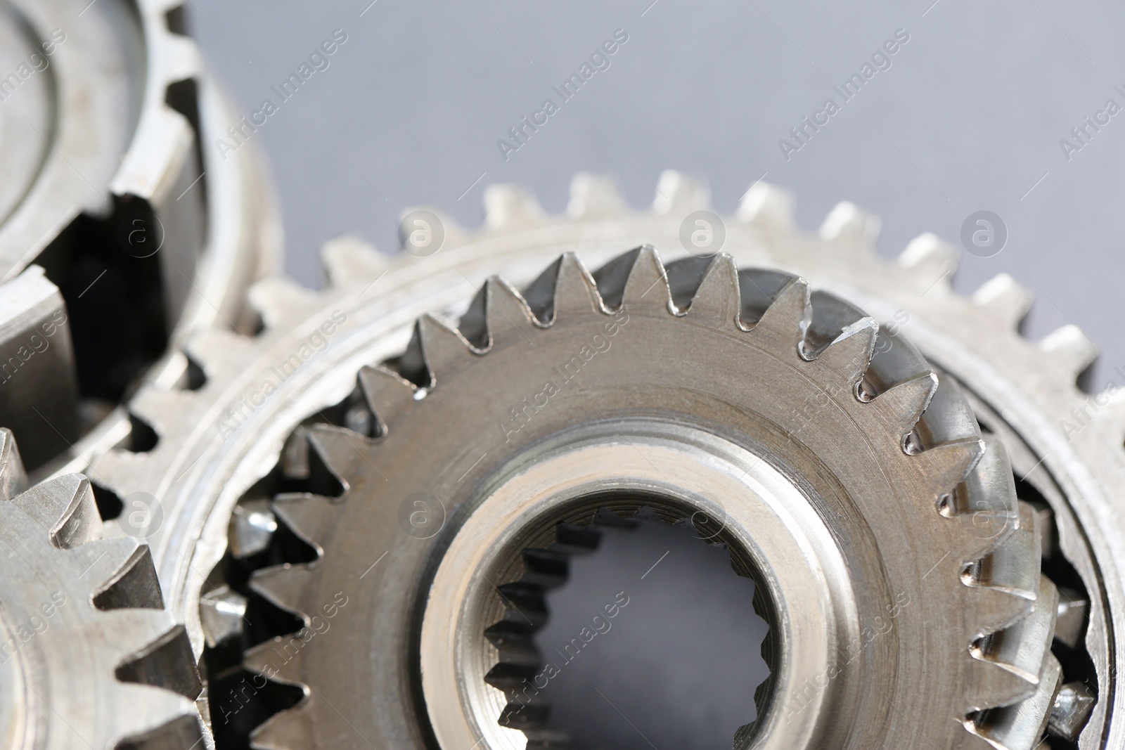 Photo of Many different stainless steel gears on grey background, closeup