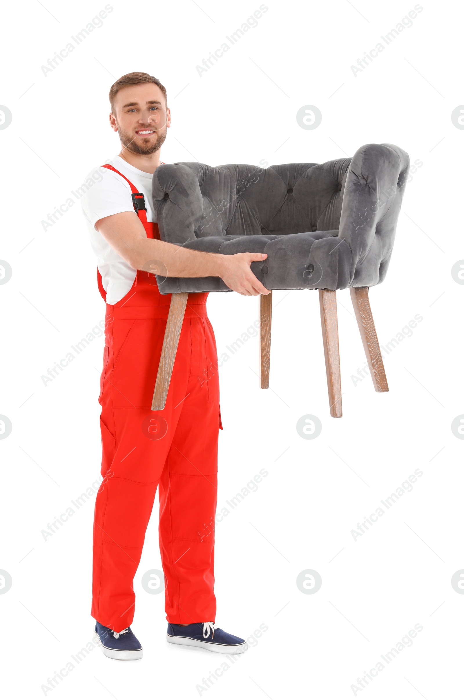 Photo of Young worker carrying armchair isolated on white. Moving service