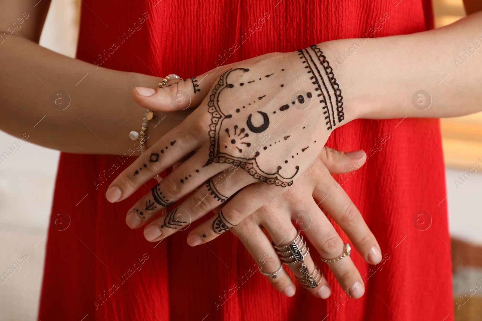 Photo of Woman with henna tattoo on hand, closeup. Traditional mehndi ornament