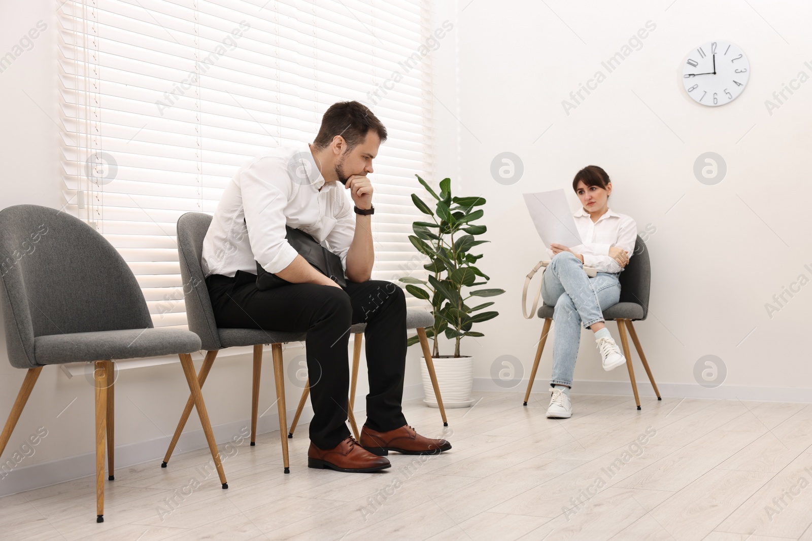 Photo of Man and woman waiting for job interview indoors