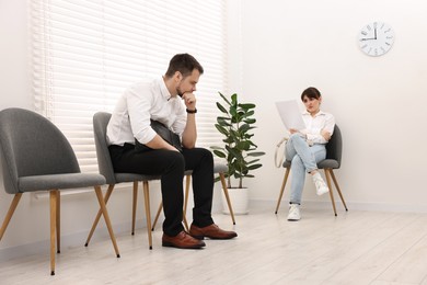 Man and woman waiting for job interview indoors