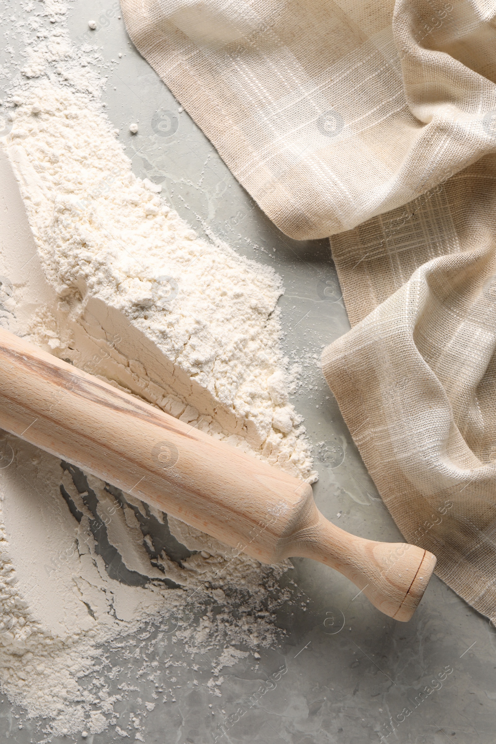 Photo of Pile of flour and rolling pin on grey marble table, top view