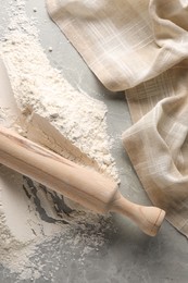 Pile of flour and rolling pin on grey marble table, top view