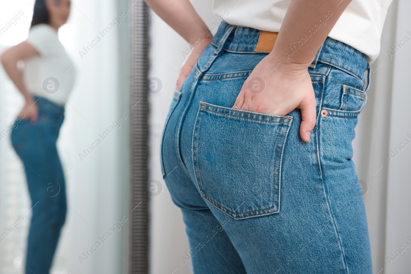 Photo of Woman in stylish jeans indoors, closeup. Space for text