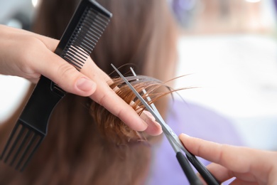 Photo of Professional hairdresser working with client in salon