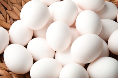 Pile of raw white chicken eggs in basket