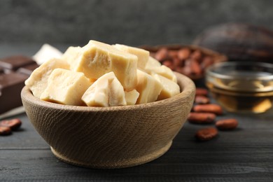 Photo of Organic cocoa butter on black wooden table, closeup