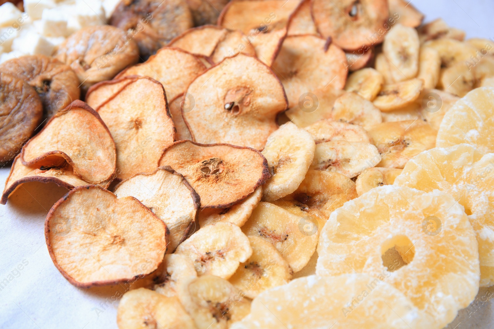 Photo of Different tasty dried fruits on paper, closeup