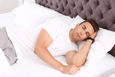 Young man sleeping in bed at home