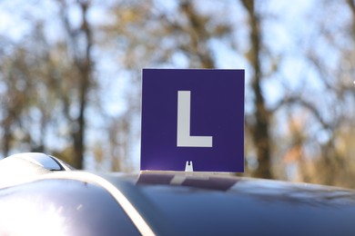 Photo of L-plate on car roof outdoors. Driving school