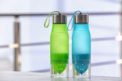 Photo of Sports water bottles on table against blurred background. Space for text