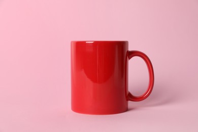 Photo of One red ceramic mug on pink background