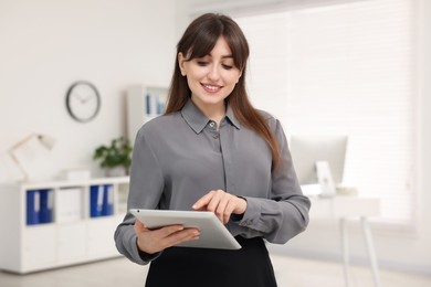 Photo of Smiling secretary working with tablet in office