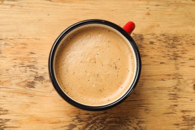 Cup of aromatic coffee on wooden table, top view