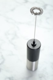 Photo of Black milk frother wand on white marble table